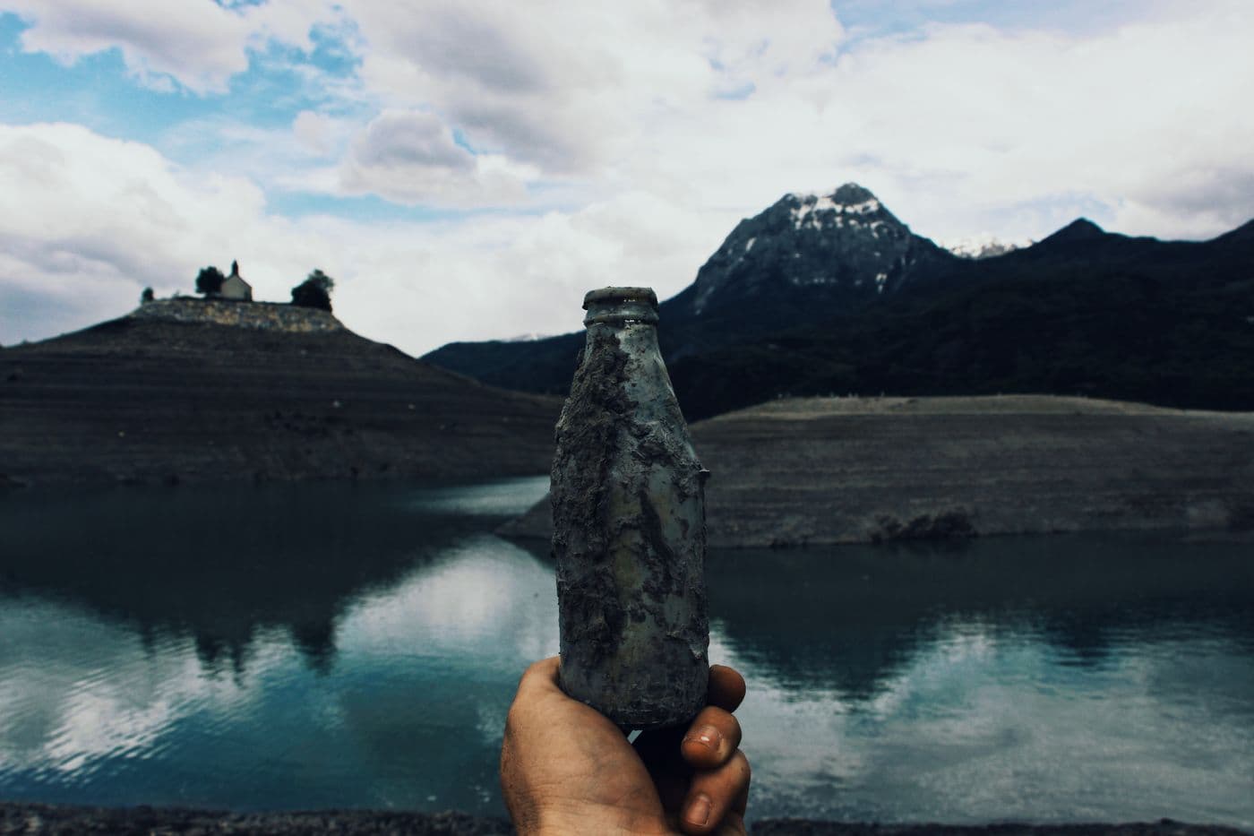 Toma de una muestra de agua en la orilla de un lago de montaña